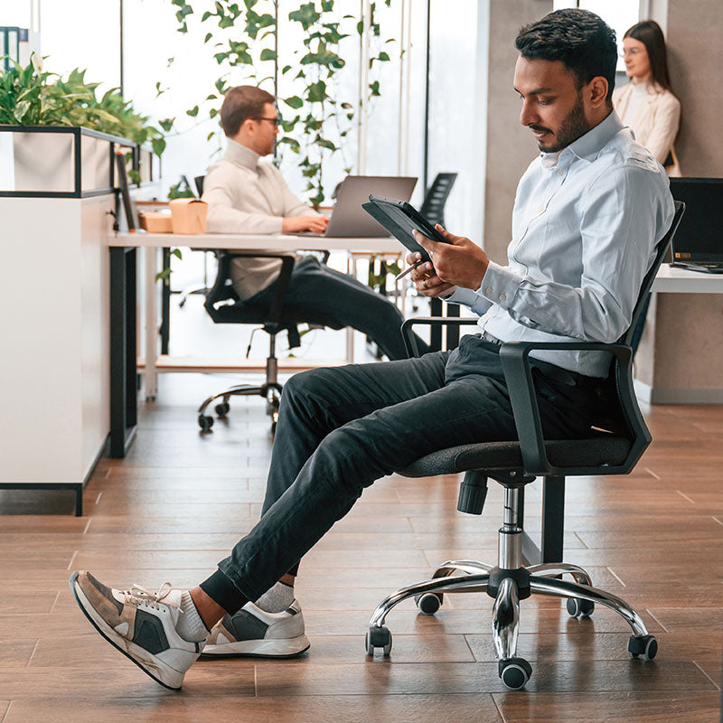 Mann auf einem Bürostuhl mit Rollen im Büro